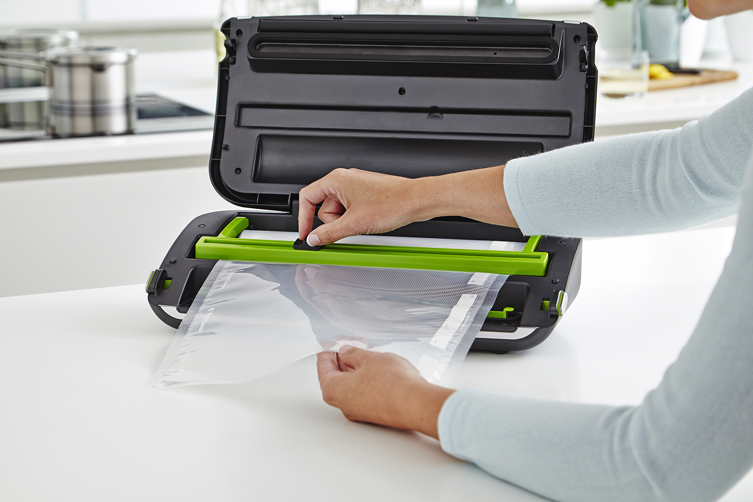 A woman closing a vacuum sealer.