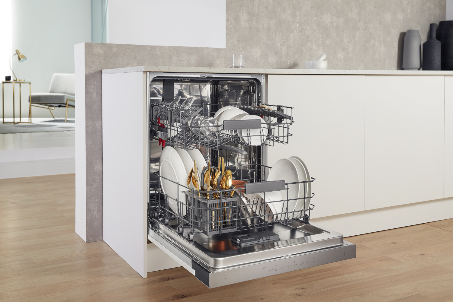 Dishwasher with open door, full of dishes and cutlery. Kitchen counter in the background.