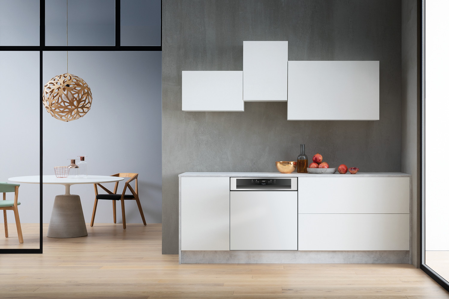Modern kitchen with white cabinets, a round table, and a light fixture. A gray wall.