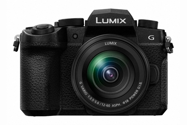 Eine schwarze Kamera mit Objektiv und dem Wort 'LUMIX'. Weißer Hintergrund.