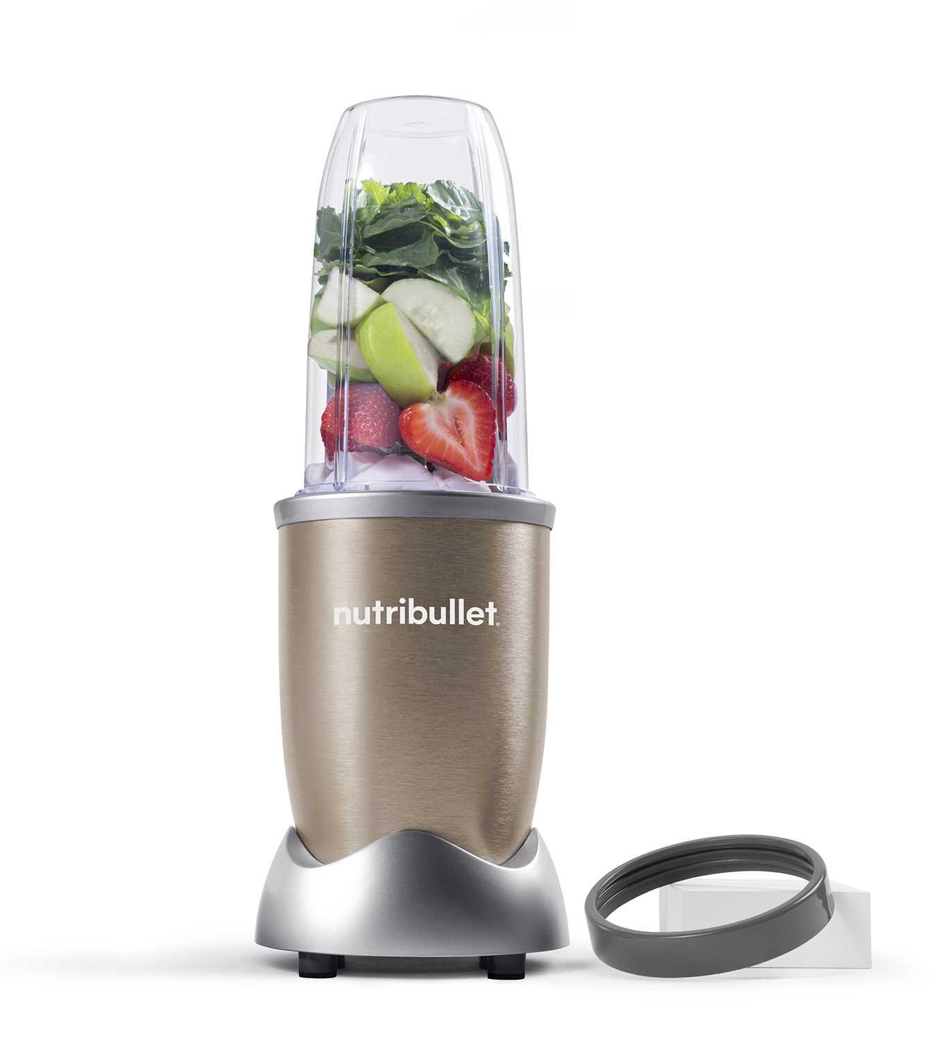Tan Nutribullet blender with fruit and greens. Transparent cup. Silver base. Black ring.