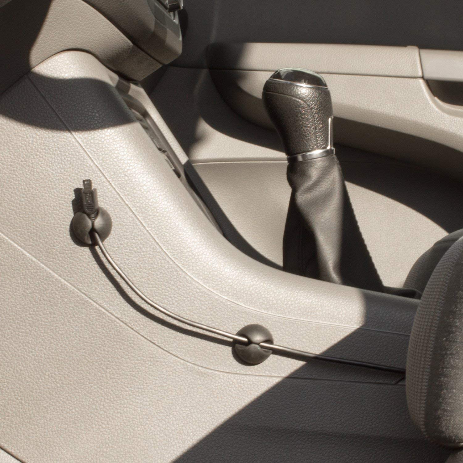Intérieur de voiture. Levier de vitesse et câble fixé par des clips, sur tableau de bord gris.