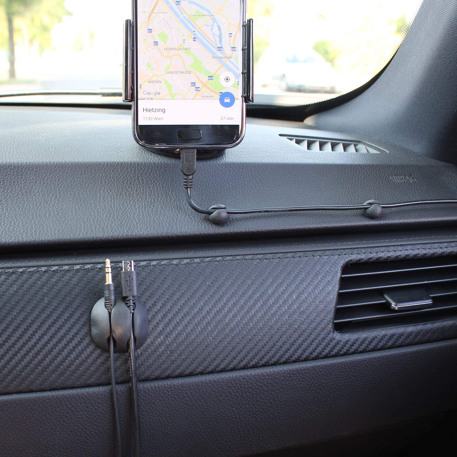 Intérieur de voiture avec téléphone sur support affichant une carte. Câbles connectés. Tableau de bord.