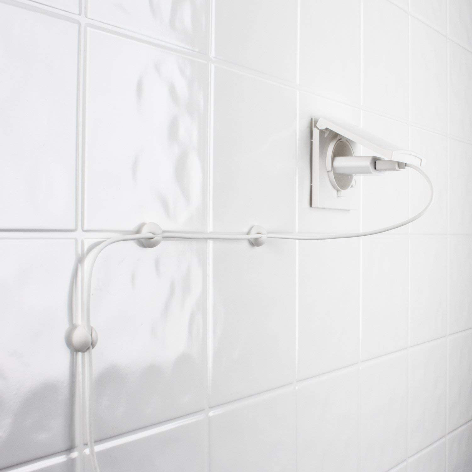 Un muro bianco con una presa di corrente e un sistema di gestione dei cavi bianco.