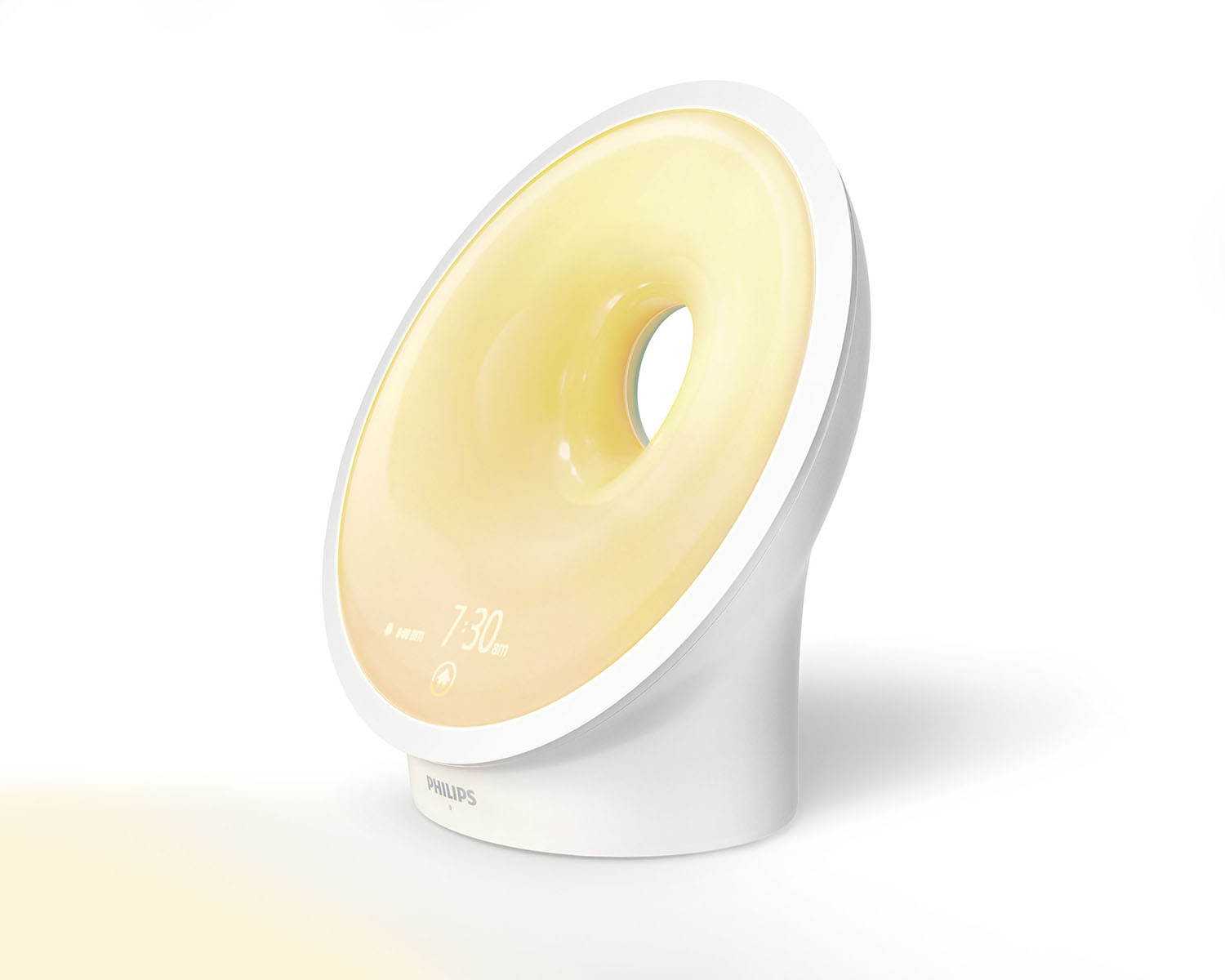 Philips wake-up light wekker. Een rond licht dat geel licht uitstraalt, witte voet.
