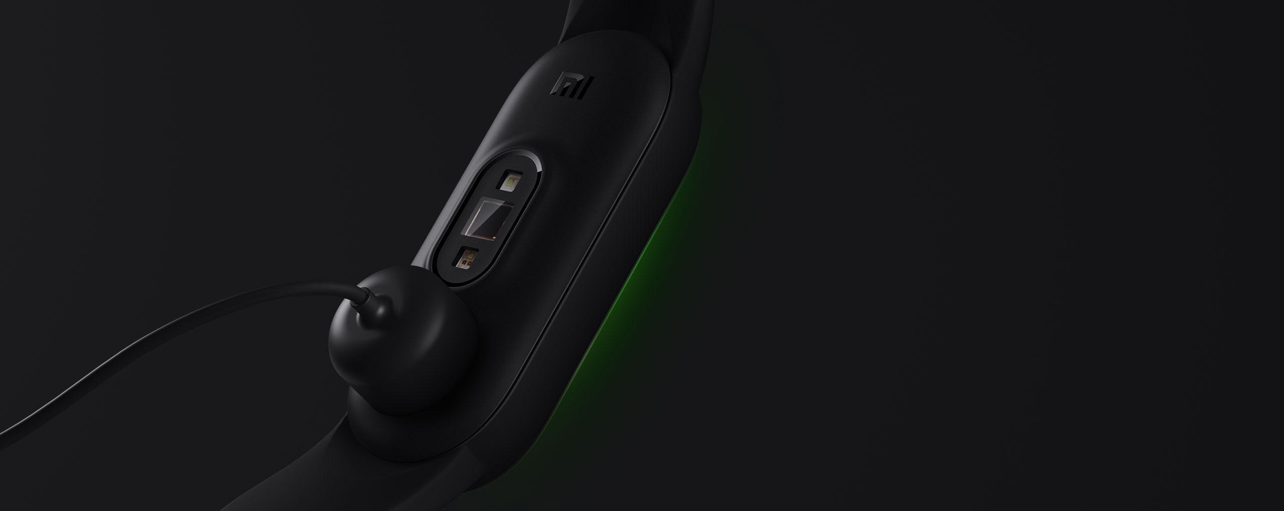 Schwarzes Mi Smart Band 5, das mit einem magnetischen Ladegerät aufgeladen wird, vor dunklem Hintergrund.