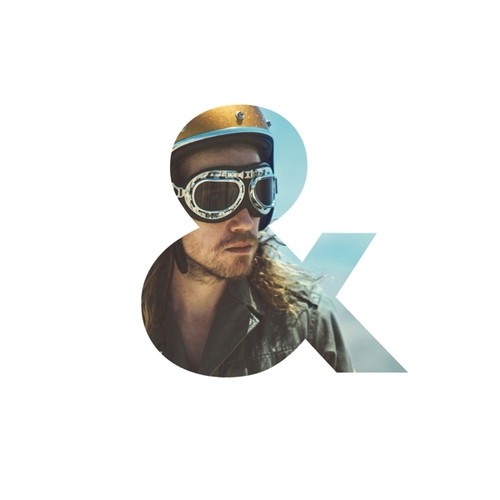 Homme avec casque et lunettes à l'intérieur du symbole esperluette, avec un fond de ciel bleu.