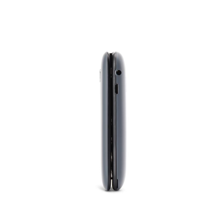 Un teléfono plegable gris oscuro cerrado se ve de lado, contra un fondo blanco.