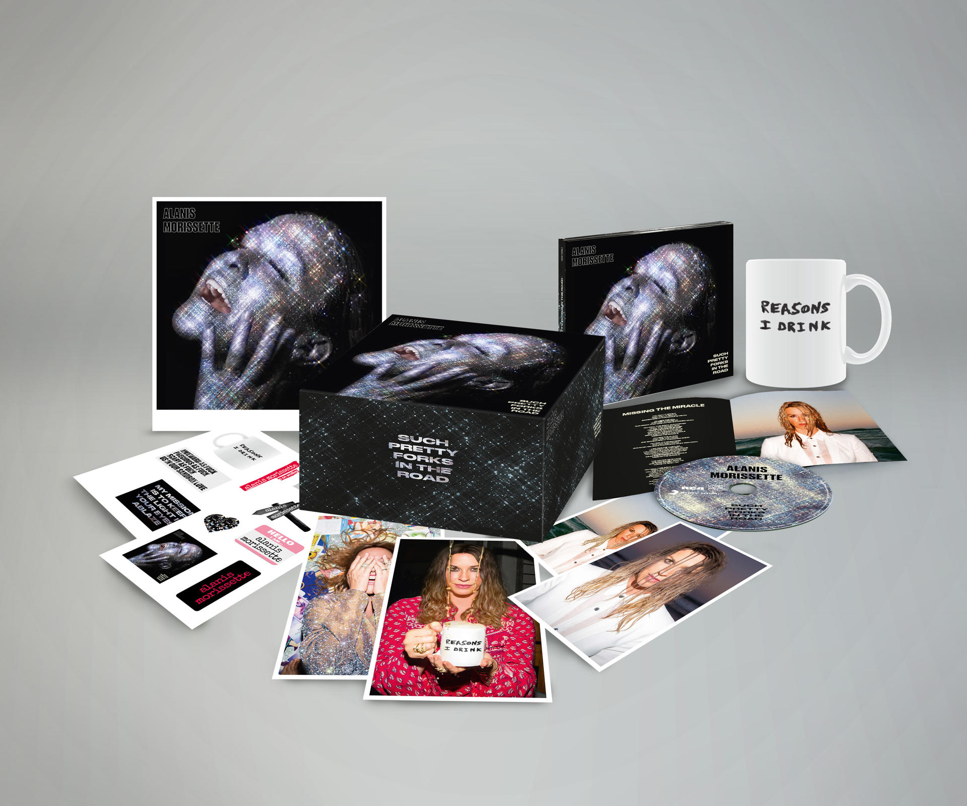Alanis Morissette album box set met foto's, een mok, een cd en andere items. De box set is zwart met zilveren glitters.