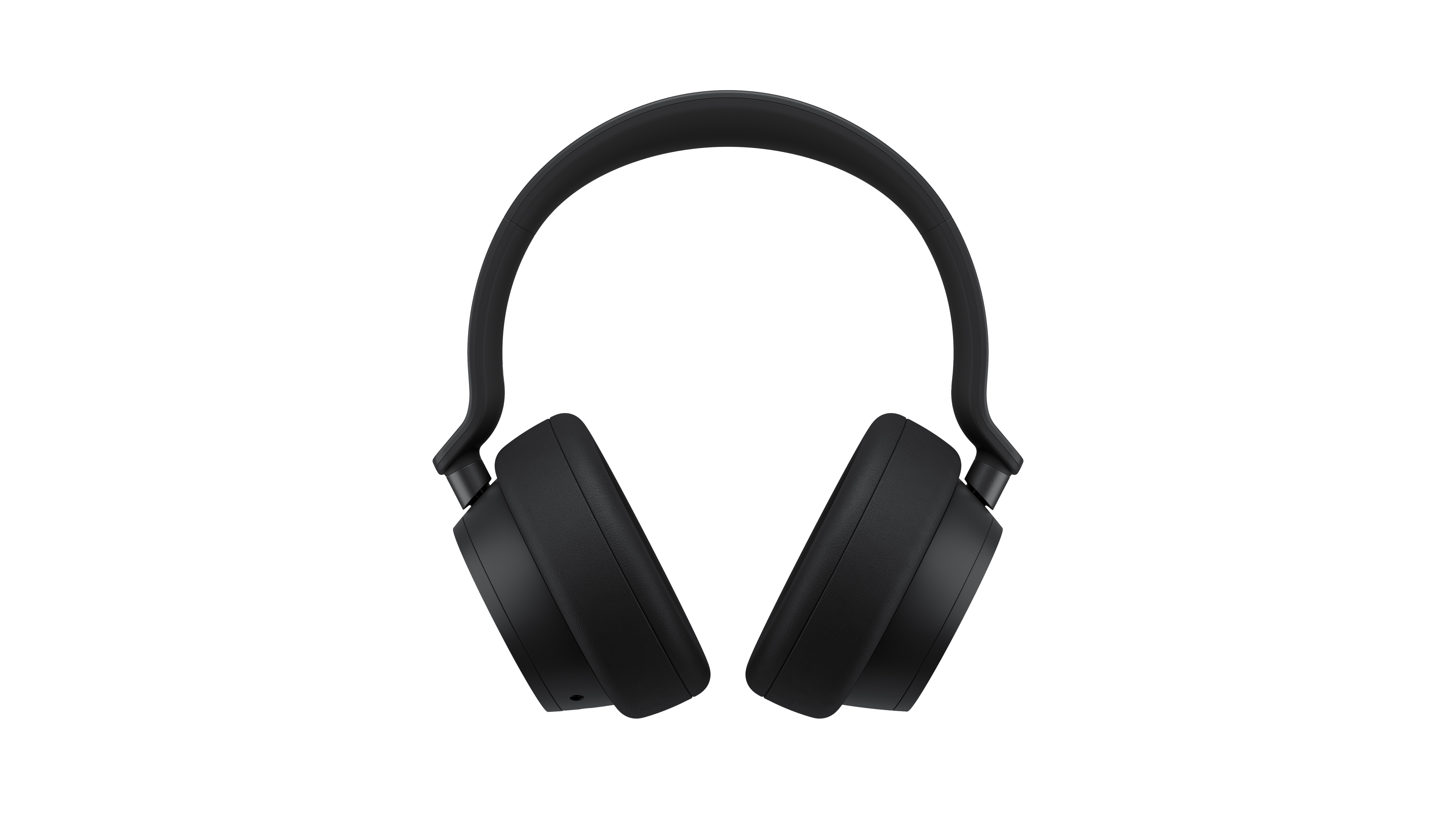 Black over-ear headphones on a black background, top view.