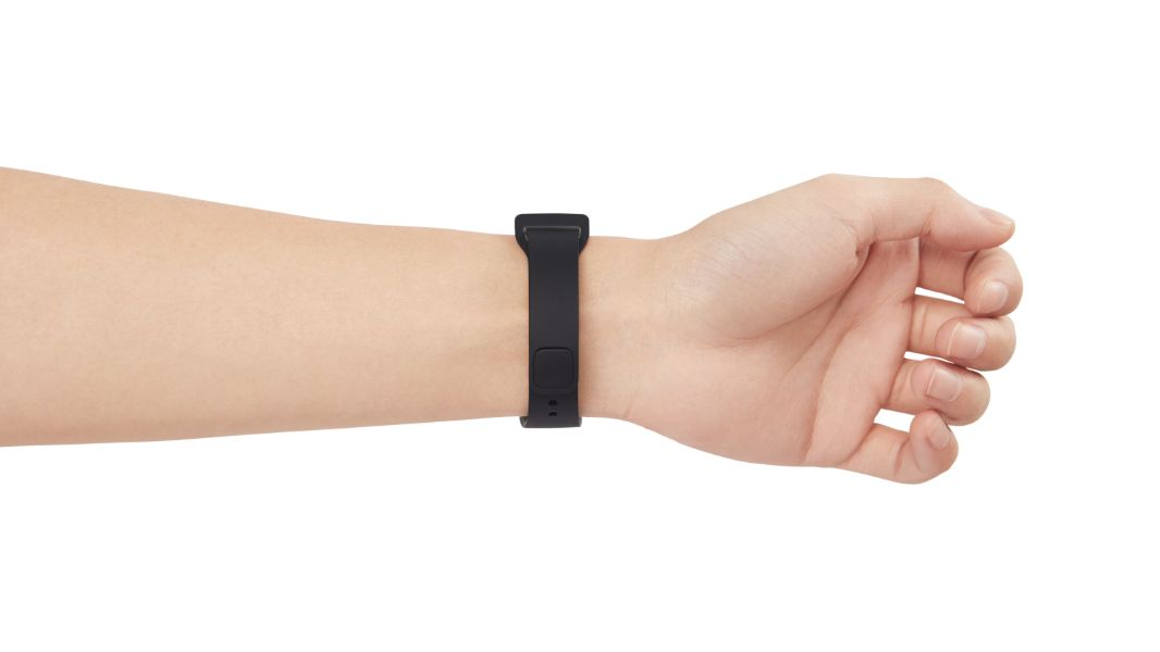 Muñeca de una persona con una pulsera inteligente negra. Fondo blanco, pulsera puesta.
