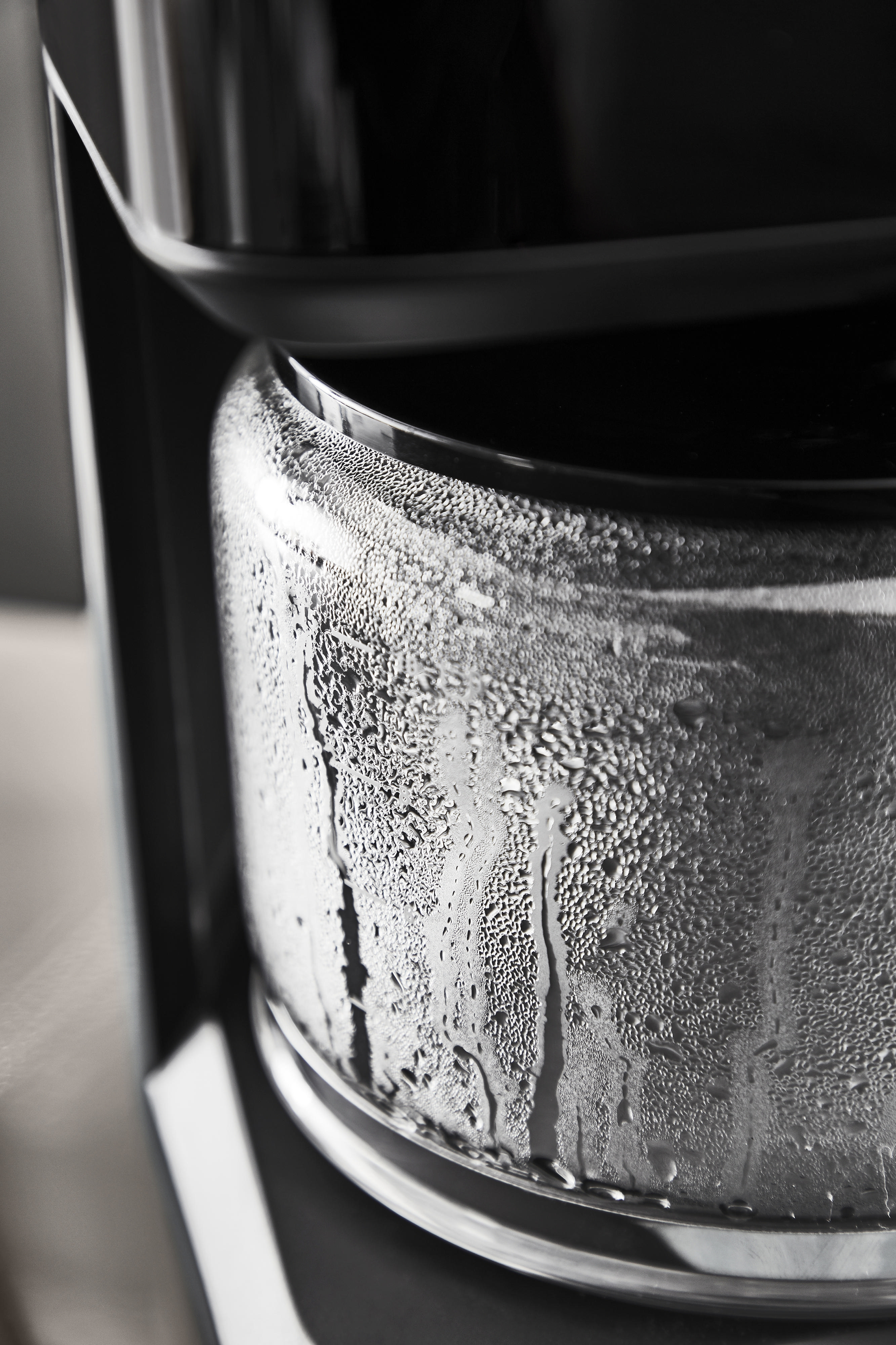 Nahaufnahme der Glaskaraffe einer Kaffeemaschine mit Kondensation außen.