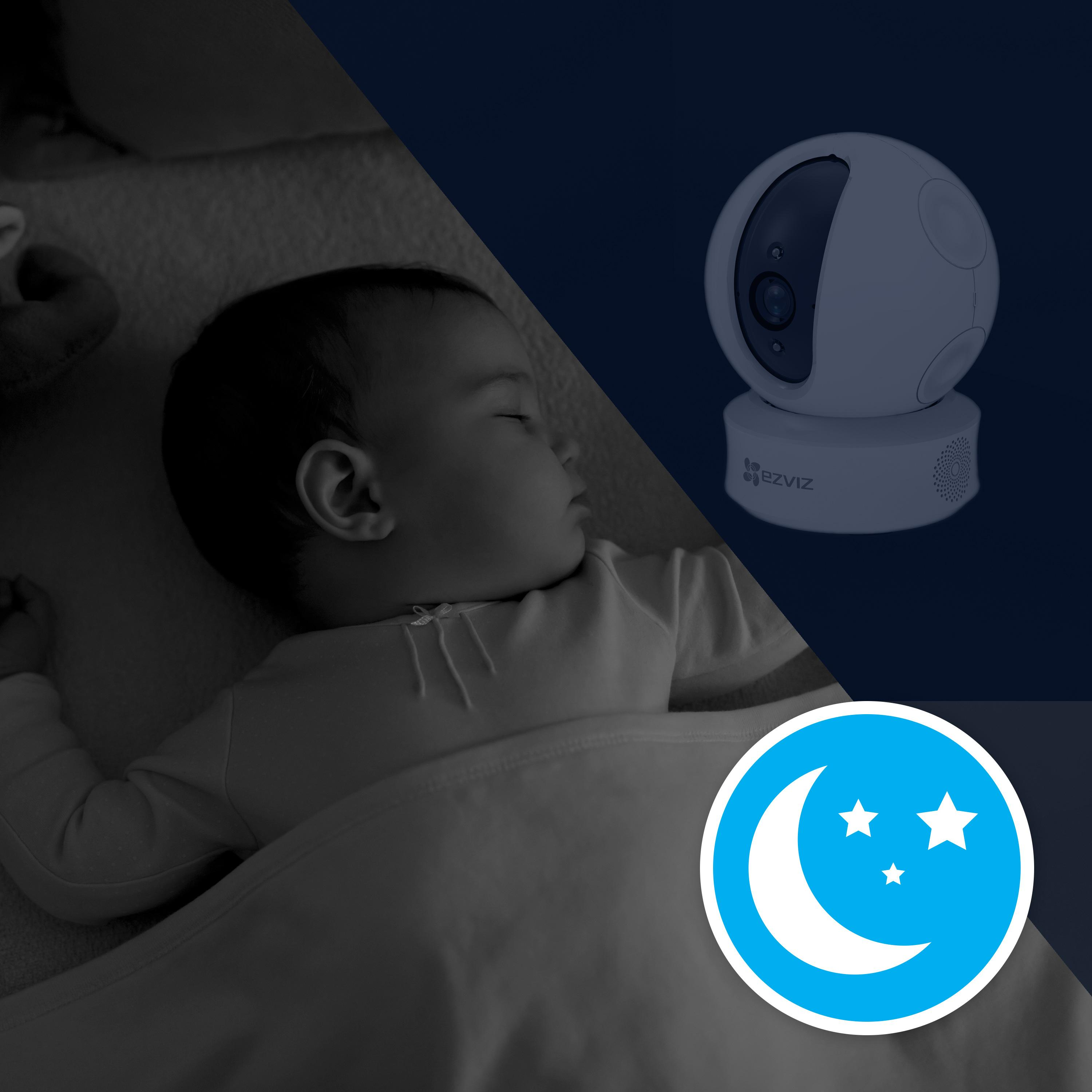 Un bebé durmiendo en una cuna junto a una cámara de seguridad de visión nocturna con un icono de media luna.