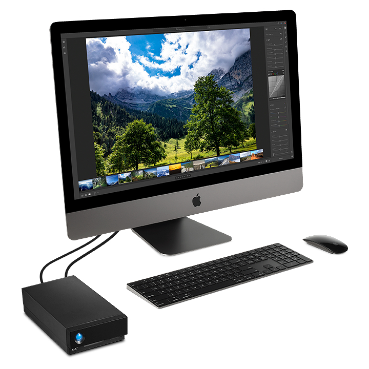 Ein Apple iMac Computer mit Monitor, Tastatur, Maus und einer schwarzen externen Festplatte.