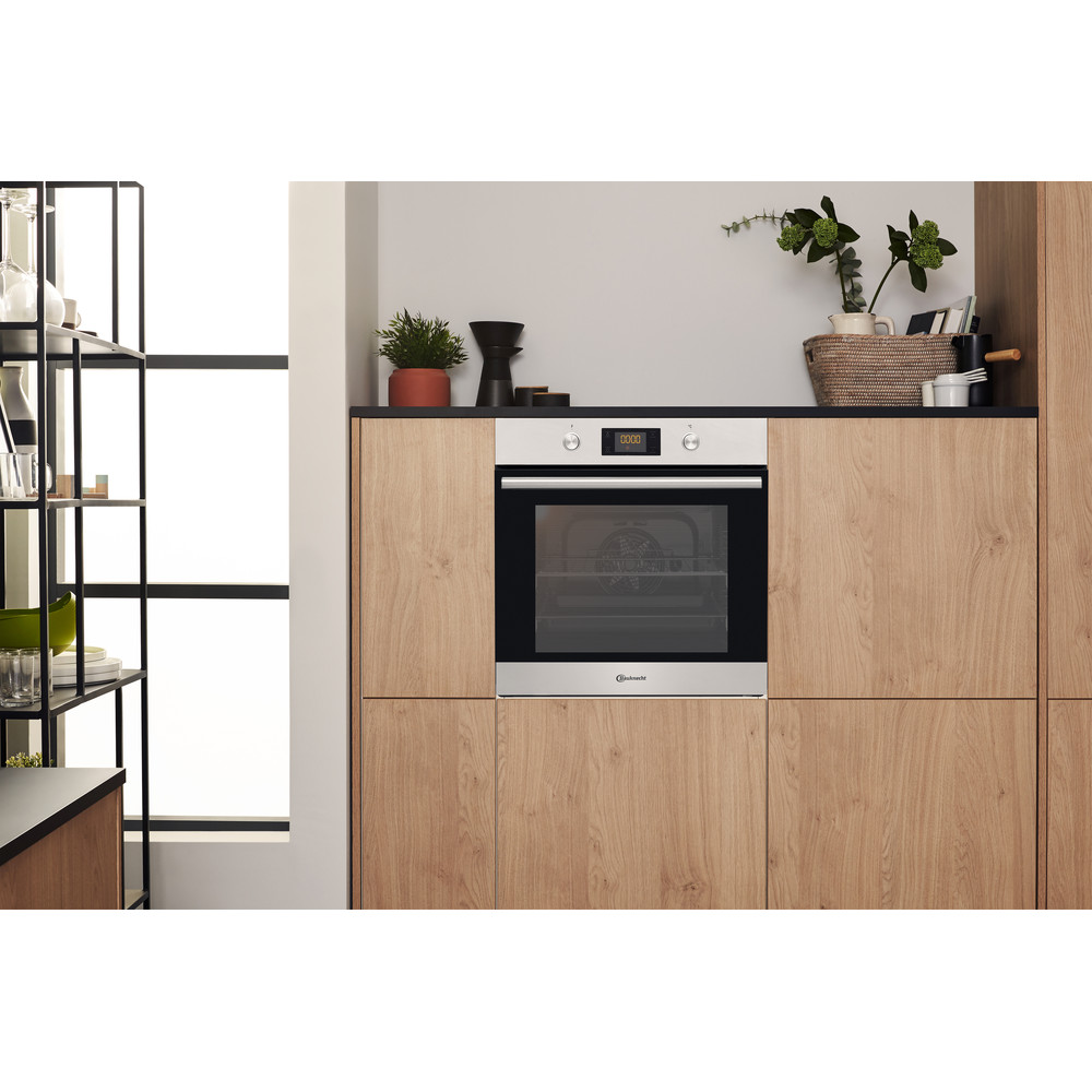 Ein Einbaubackofen in einer Küche. Holzschränke und ein Edelstahlbackofen.