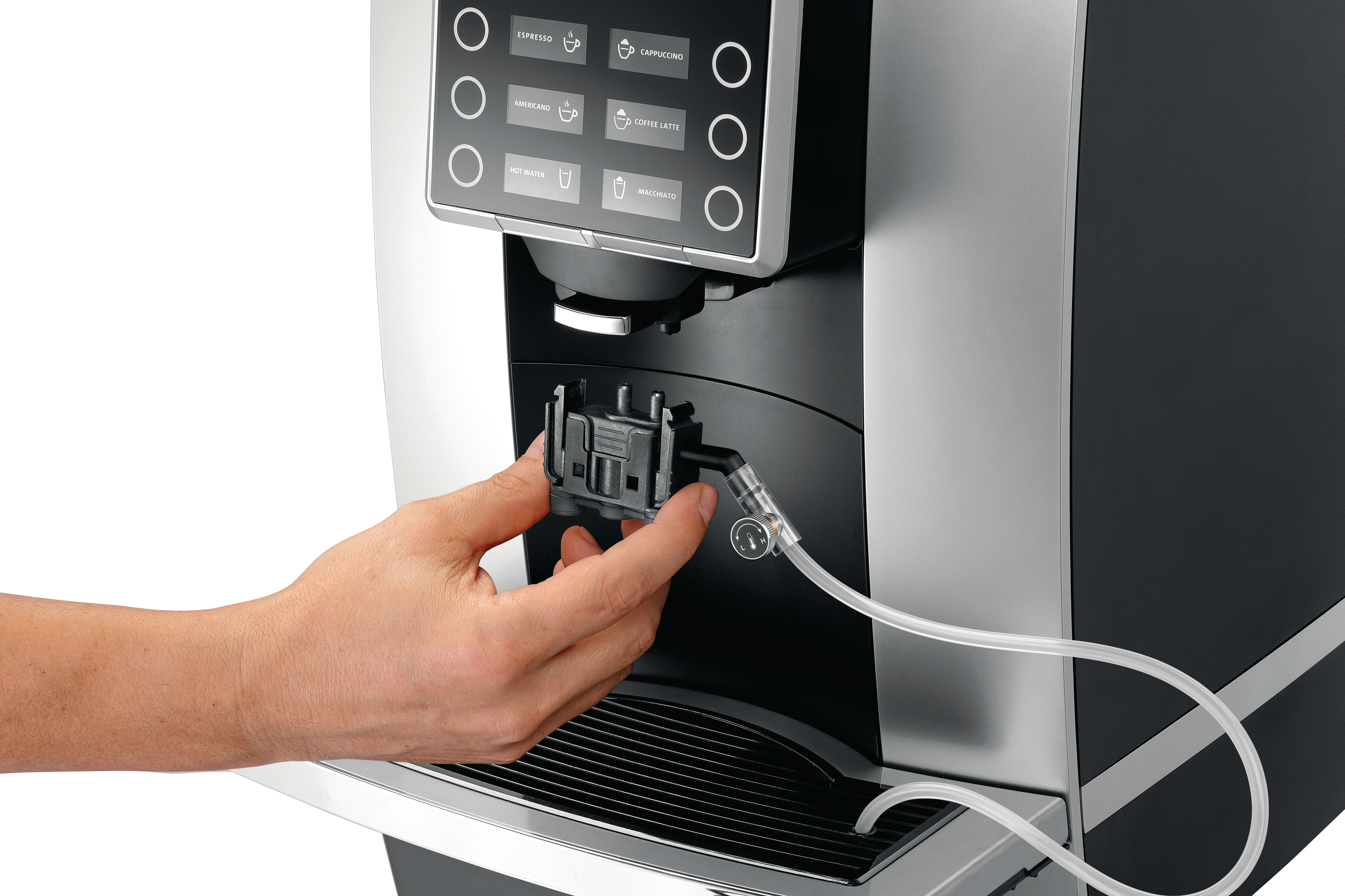 Eine Hand hält einen schwarzen Stecker an einer Kaffeemaschine. Ein Schlauch ist angeschlossen.