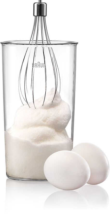 Braun hand blender with whisk attachment, bowl with whipped cream, and two eggs.