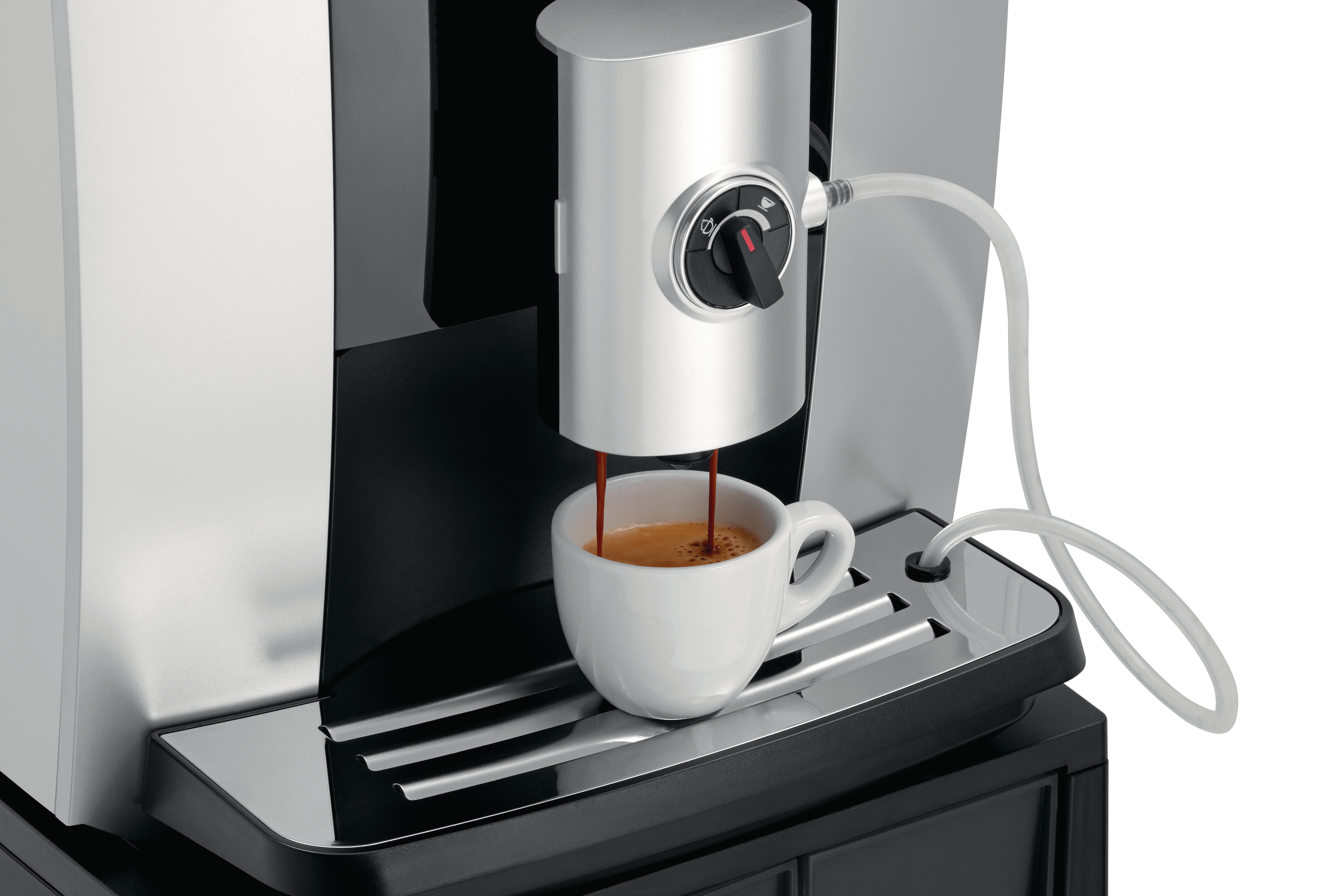 Espressomaschine, die Kaffee in eine weiße Tasse auf einem Metalltablett gießt.