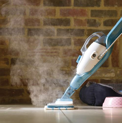 Steam cleaner cleaning a floor. Steam coming out. Brick wall in the background.
