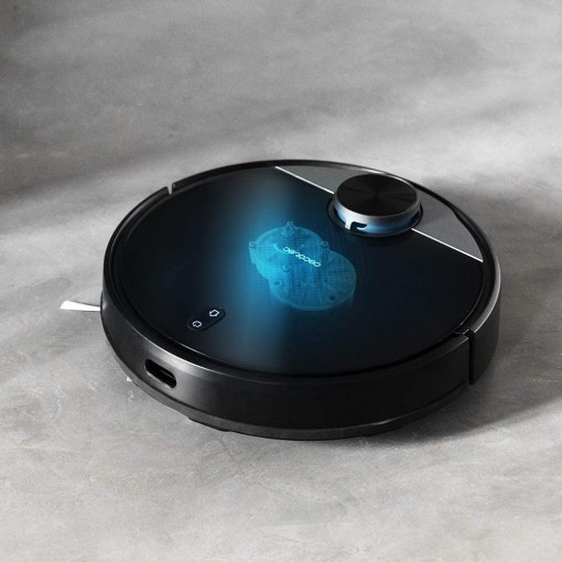 Aspiradora robot negra sobre una superficie gris. Efecto de luz azul visible.
