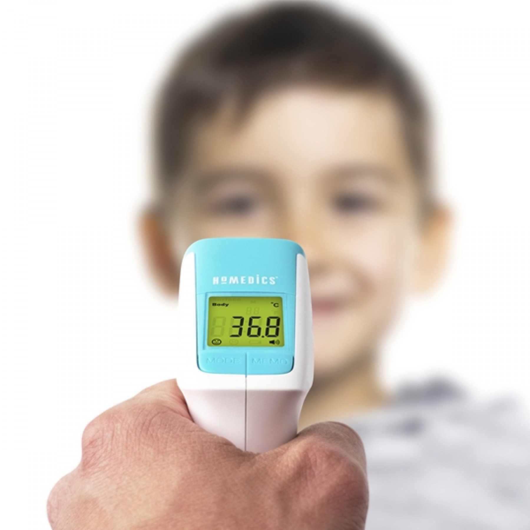 Hand met thermometer. Toont 36,8°C. Vage achtergrond van een jongen.