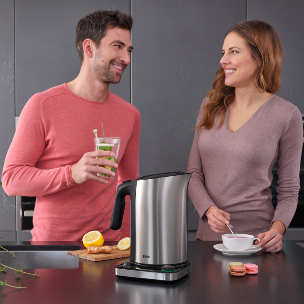 Zwei Personen in einer Küche, mit Wasserkocher und Teeservice.