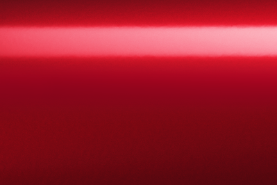 Nahaufnahme einer roten, glänzenden Oberfläche. Lichtreflexion in der Mitte. Einfarbiger Hintergrund.