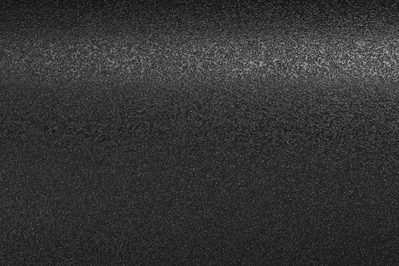 Eine strukturierte schwarze Oberfläche, dezent beleuchtet, wodurch ein körniges Aussehen entsteht.