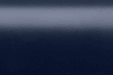 Nahaufnahme einer marineblauen, glänzenden Oberfläche mit subtilen Glanzlichtern und Reflexionen.