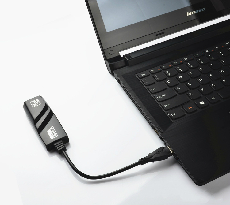 Siyah bir adaptöre bağlı bir USB kablosu olan siyah bir dizüstü bilgisayar.