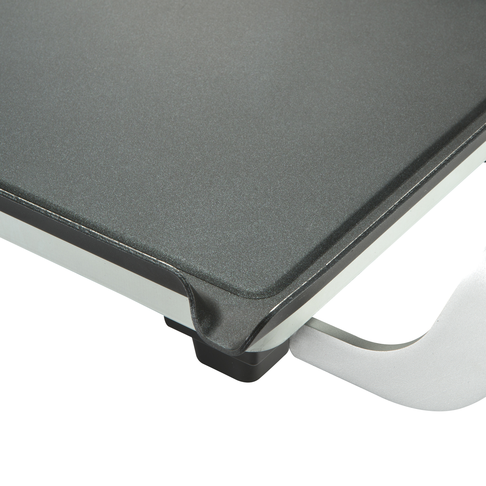 Close-up of a black griddle surface with white handle.