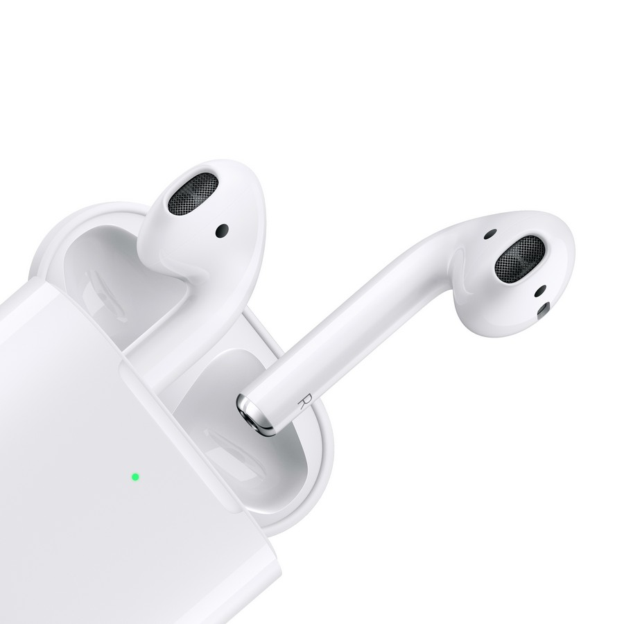Auriculares inalámbricos blancos en un estuche de carga, un auricular fuera.
