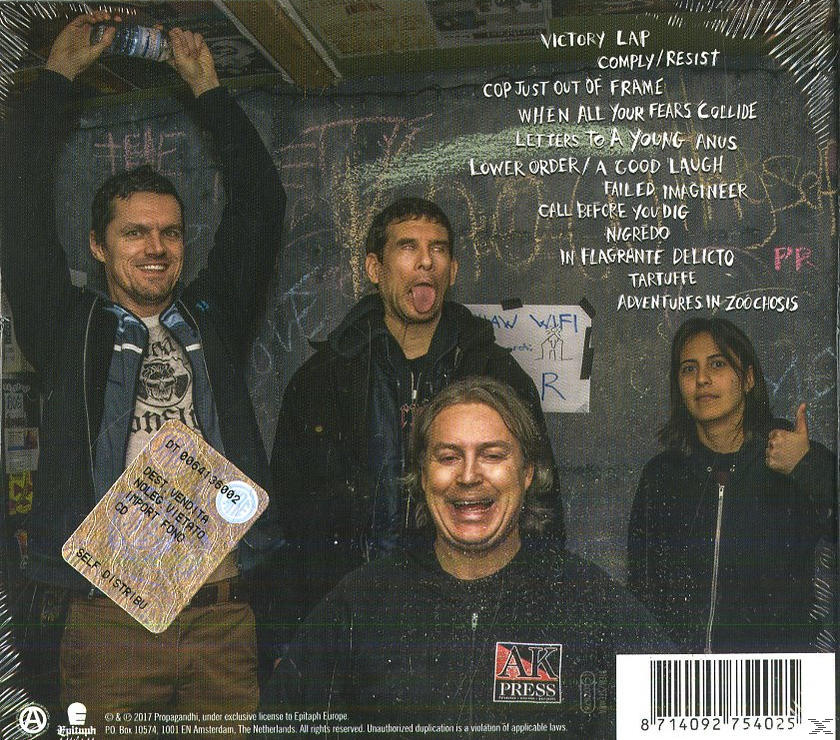 Vier Personen lächeln und posieren. Text auf der Rückseite des Albums. Hintergrund ist eine Tafel.
