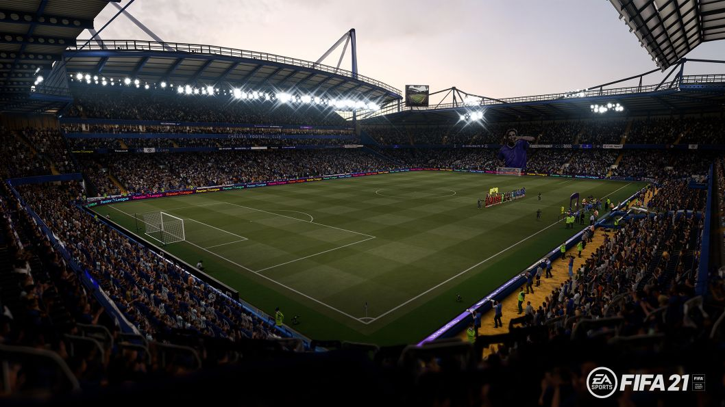 Estadio de fútbol con campo verde. Gradas vacías con luces brillantes.