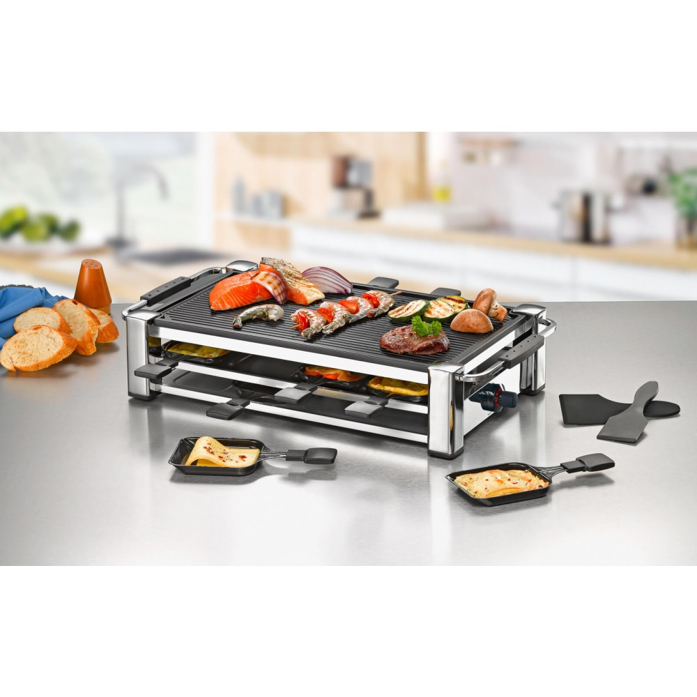 Raclette-Grill mit Essen: Lachs, Zwiebeln, Kartoffeln und Käse in kleinen Pfannen, auf einem Tisch.