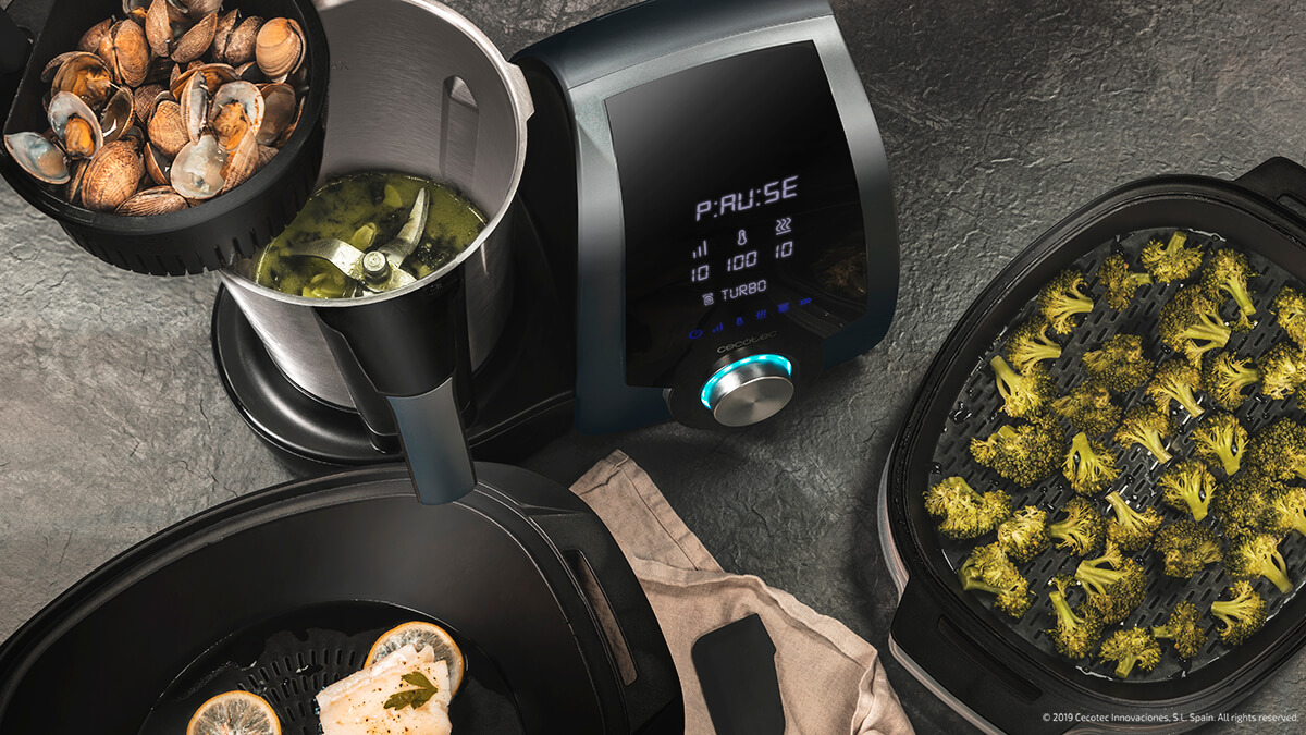 Un electrodoméstico de cocina con almejas, sopa y brócoli en recipientes separados.