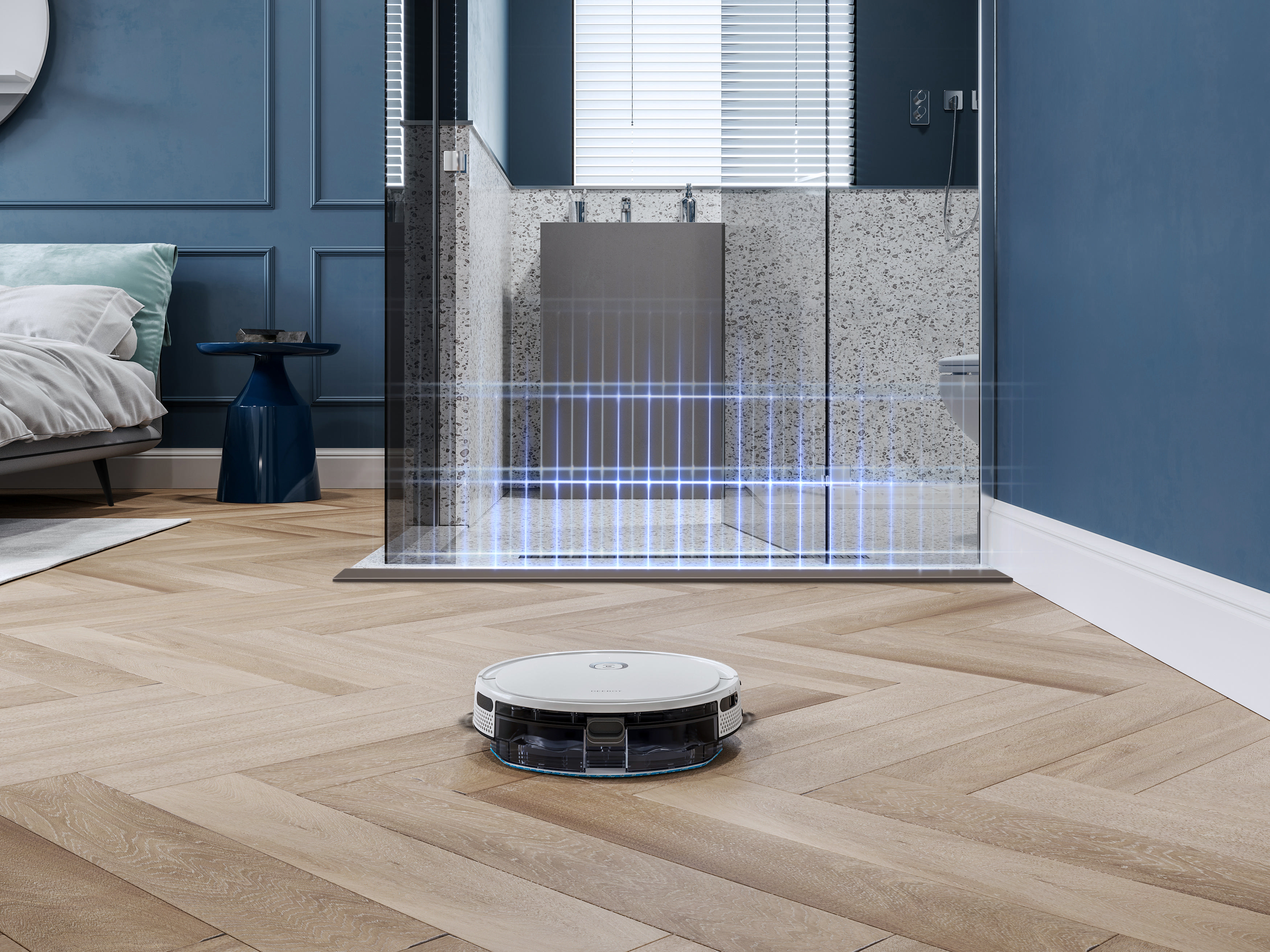 Ein Roboter-Staubsauger auf einem Holzboden. Im Hintergrund sind eine Dusche und ein Bett zu sehen.