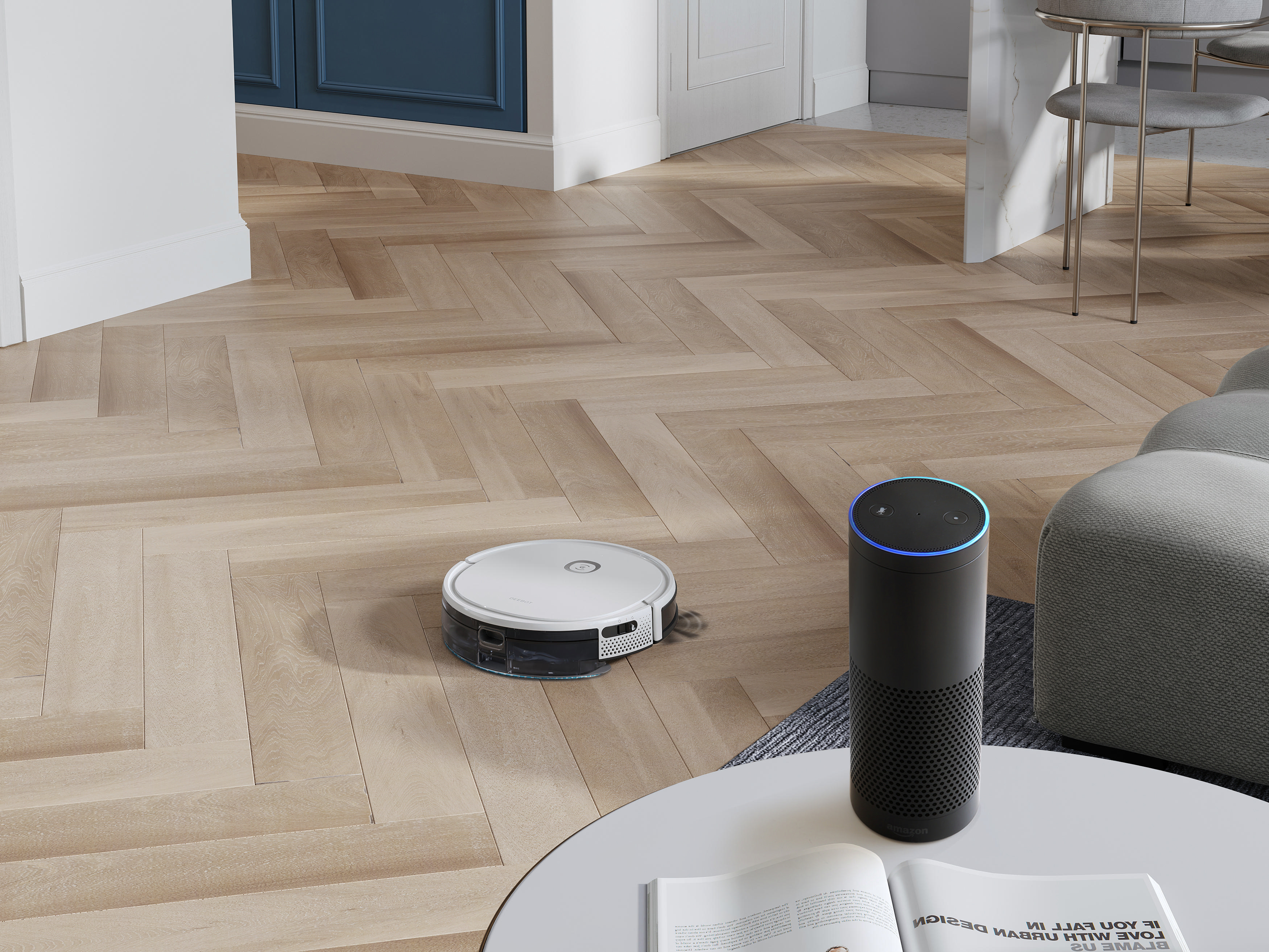 Ein Staubsaugerroboter und ein intelligenter Lautsprecher auf einem Holzboden. Ein weißer Tisch und eine graue Couch sind zu sehen.