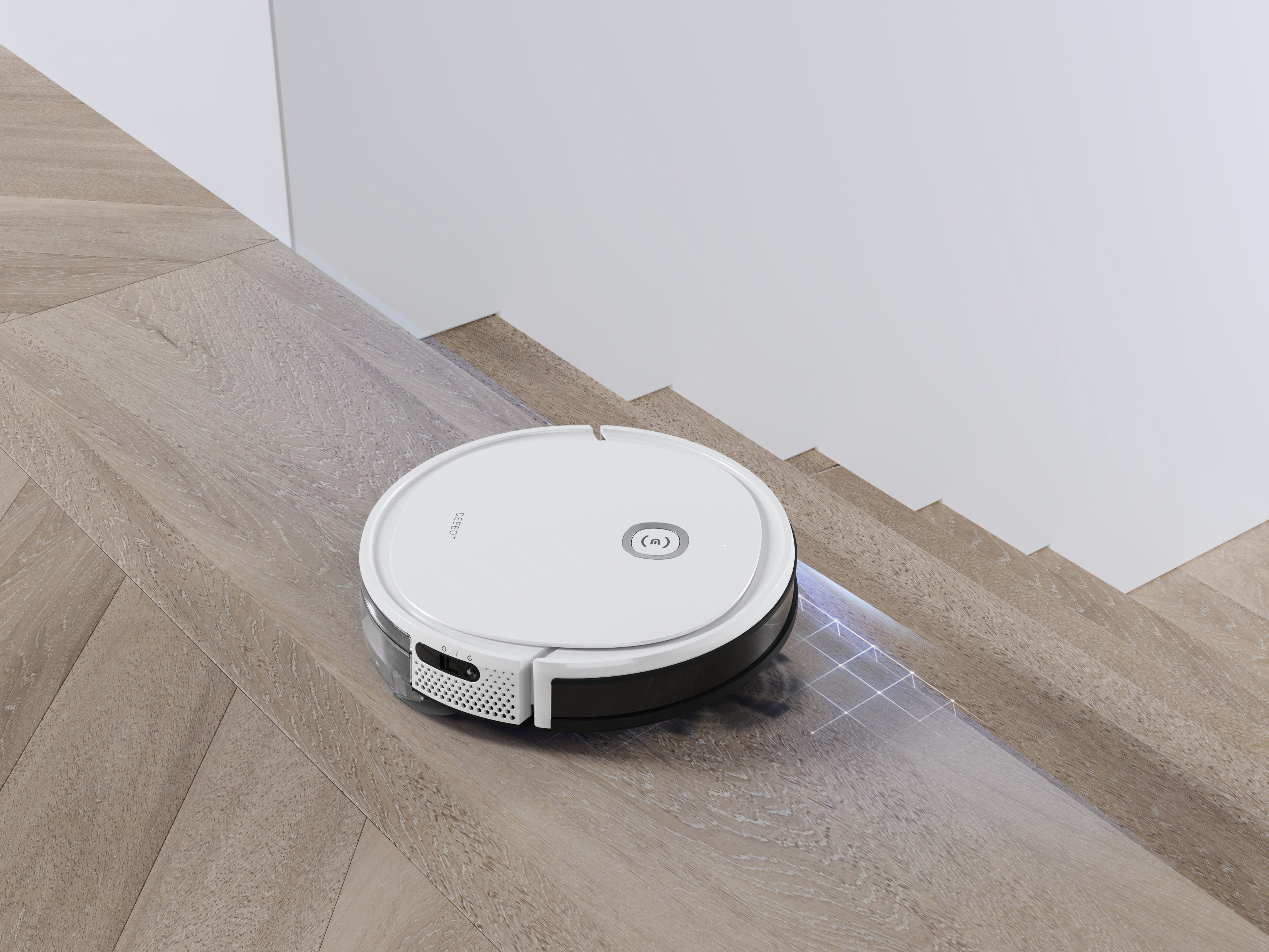 Ein weißer Roboter-Staubsauger auf Holztreppen. Er befindet sich in der Nähe weißer Wände.
