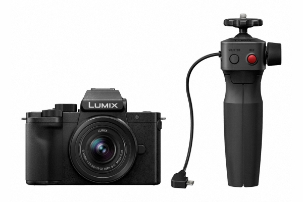 Schwarze Lumix-Kamera mit befestigtem schwarzem Griff/Stativ auf weißem Hintergrund.