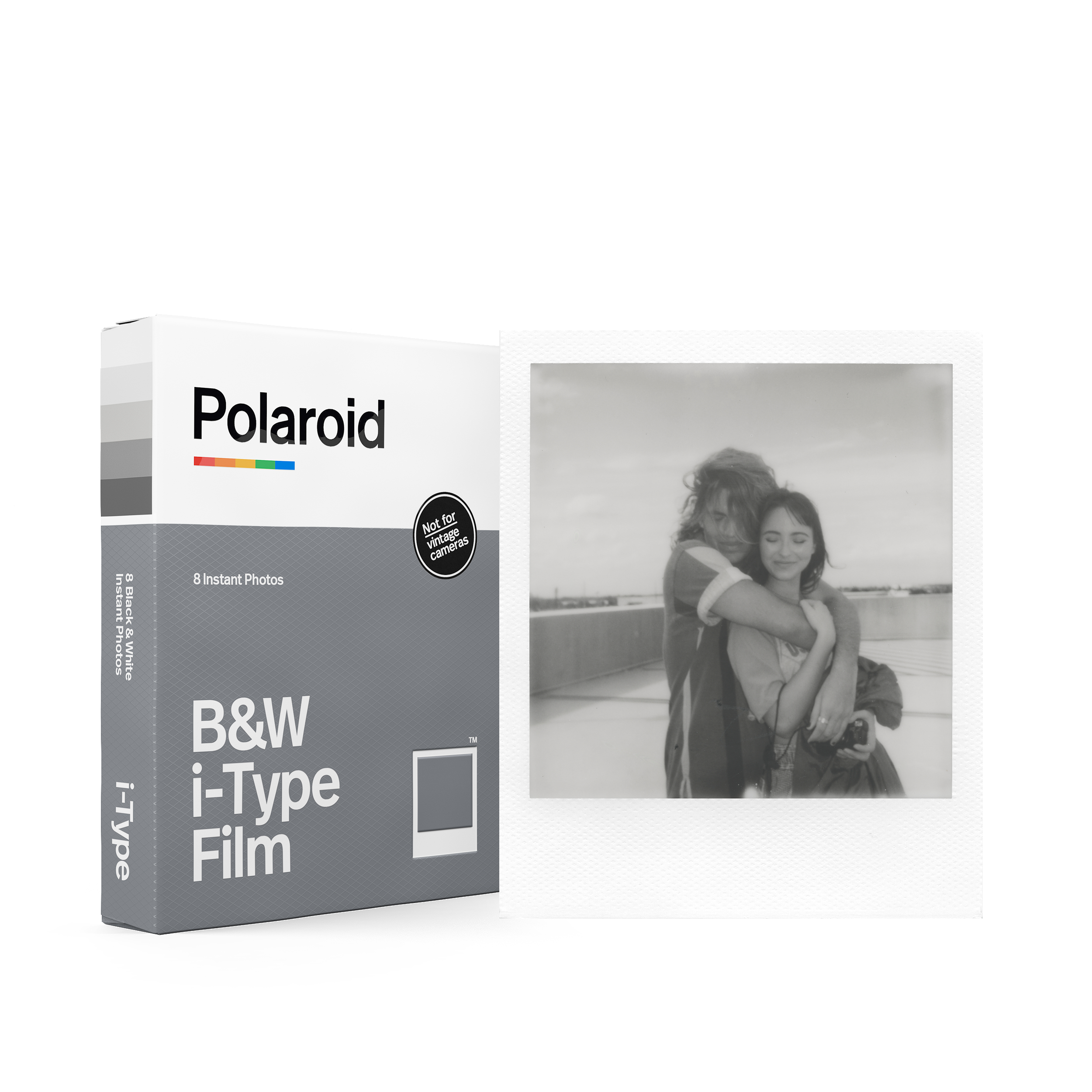 Eine Polaroid-Filmbox und ein Schwarz-Weiß-Foto. Das Foto zeigt ein Paar, das sich umarmt.