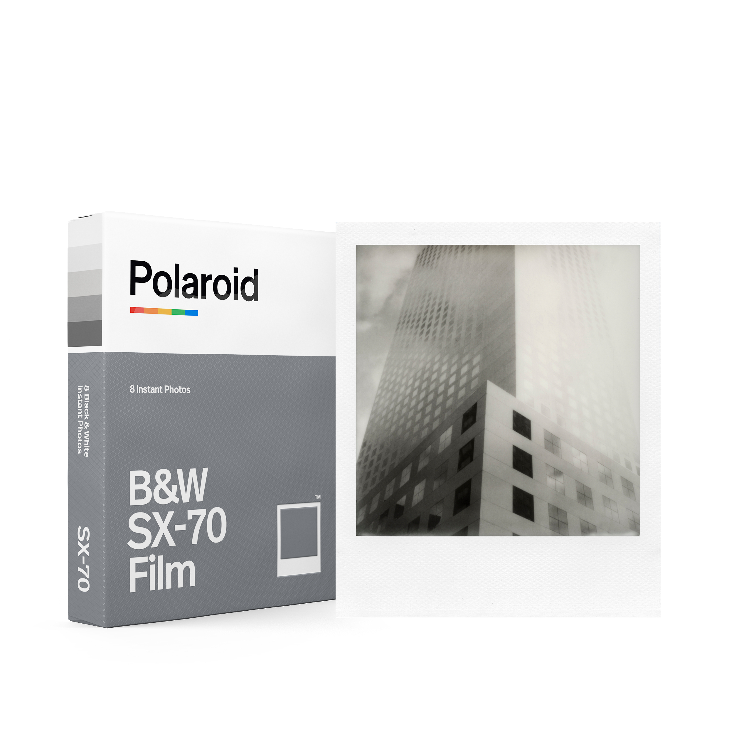 Polaroid-Filmbox und ein gedrucktes Foto eines Gebäudes mit einer hohen Struktur. Schwarz und weiß.