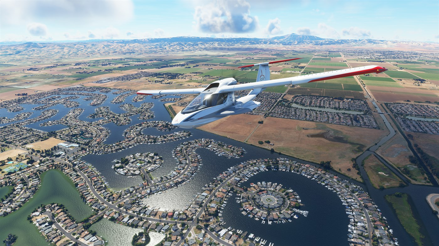 Avion volant au-dessus d'un paysage. L'eau et les bâtiments remplissent l'arrière-plan.