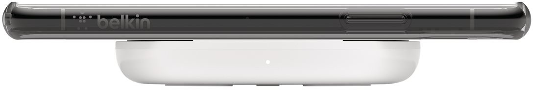 Un socle de chargement sans fil blanc avec un téléphone dessus, avec le logo Belkin visible.