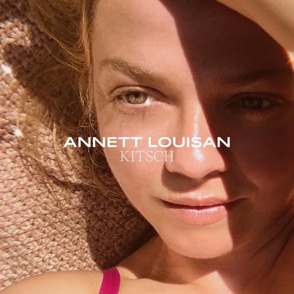 Nahaufnahme eines Frauengesichts mit Sonnenlicht. Text sagt "ANNETT LOUISAN KITSCH".