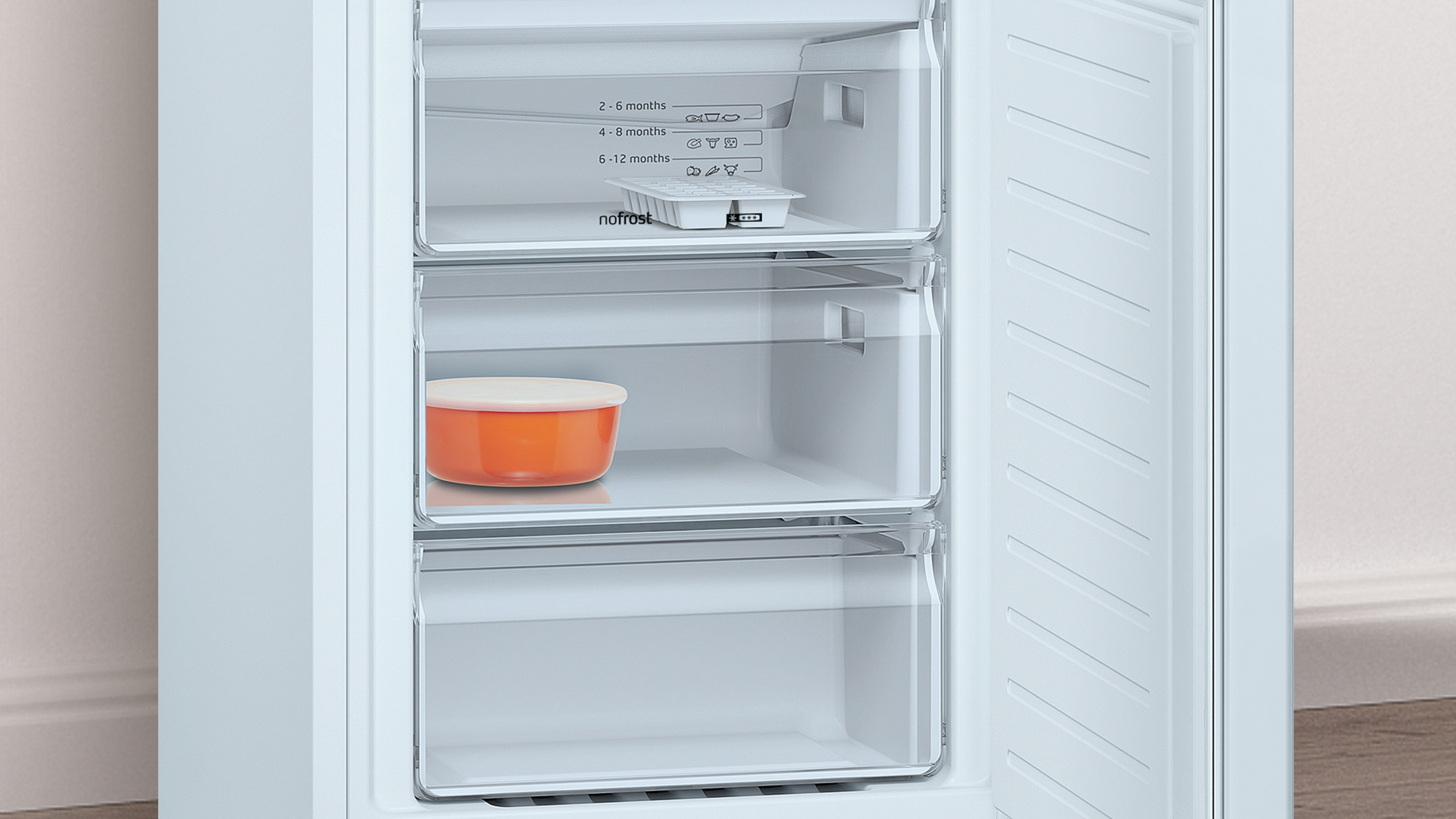 Congelador abierto con estantes. Un recipiente naranja está en un estante.