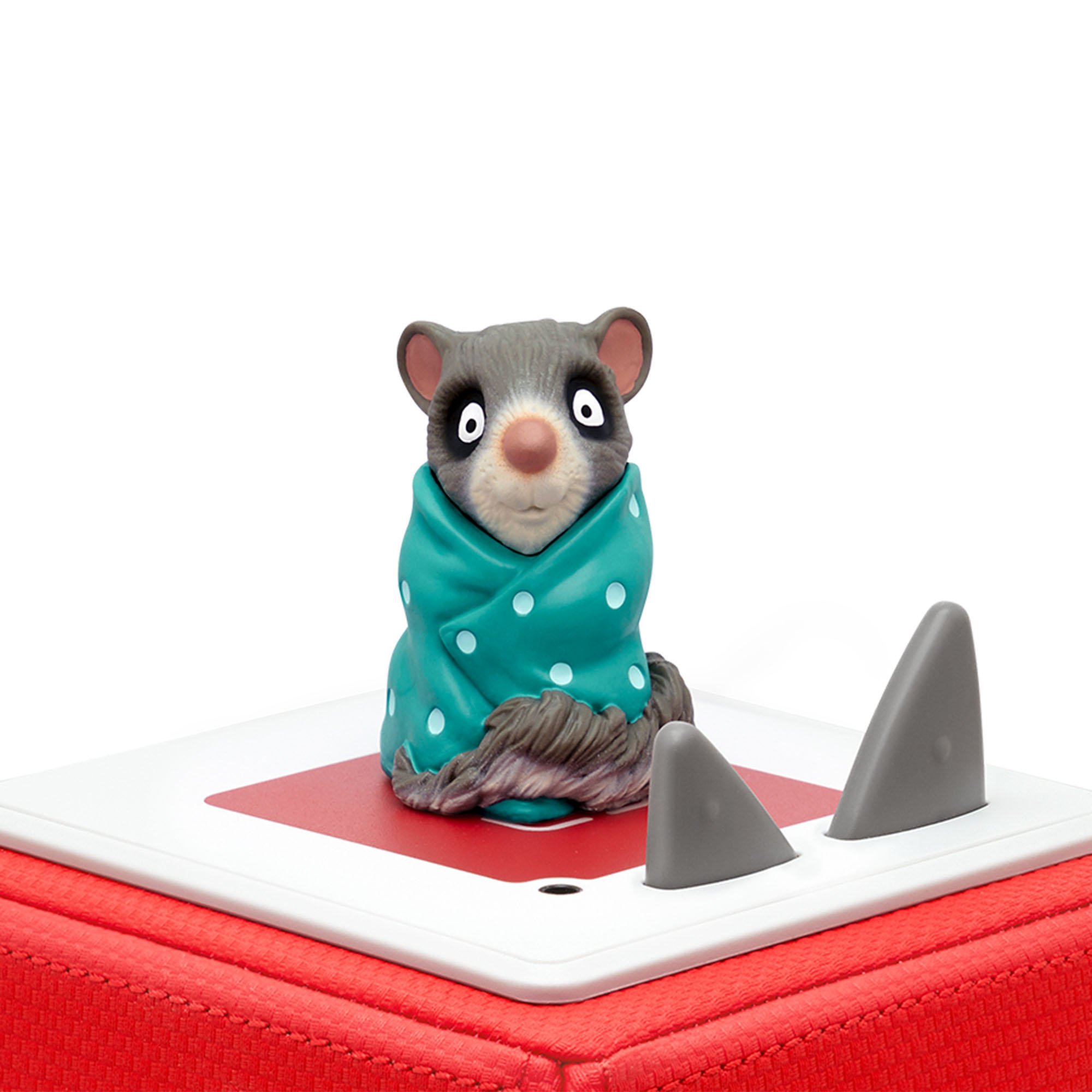 Ein Cartoon-Opossum in einer türkisfarbenen Decke sitzt auf einem rot-weißen Quadrat.