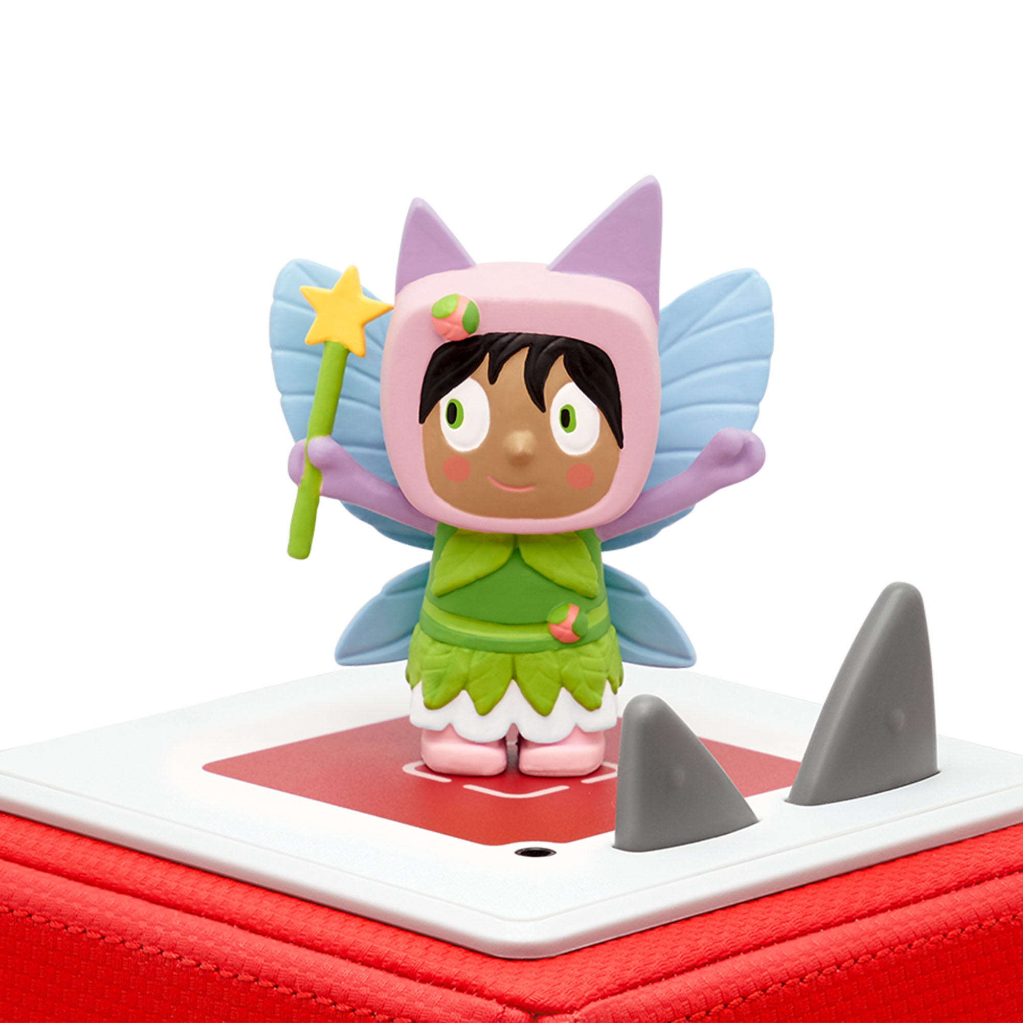 Eine Spielzeug-Feenfigur, die auf einer roten Basis mit Haifischflossen steht. Sie hat einen Zauberstab und Flügel.