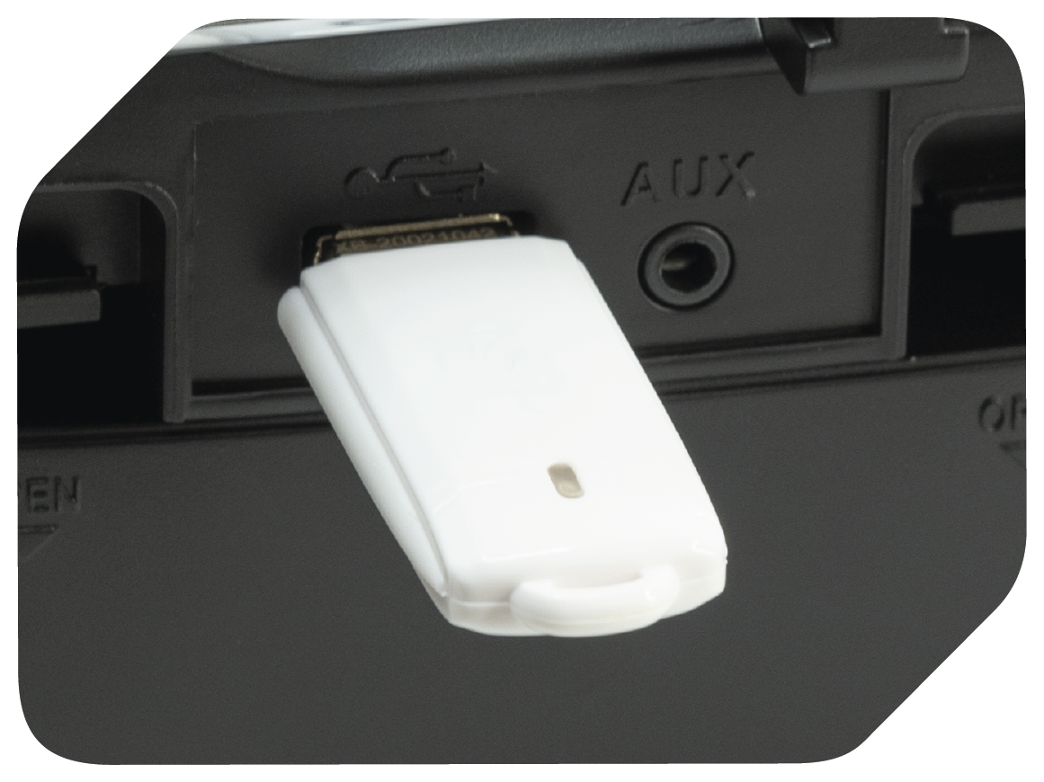 Weißer USB-Stick in ein schwarzes Gerät eingesteckt, mit AUX-Anschluss.