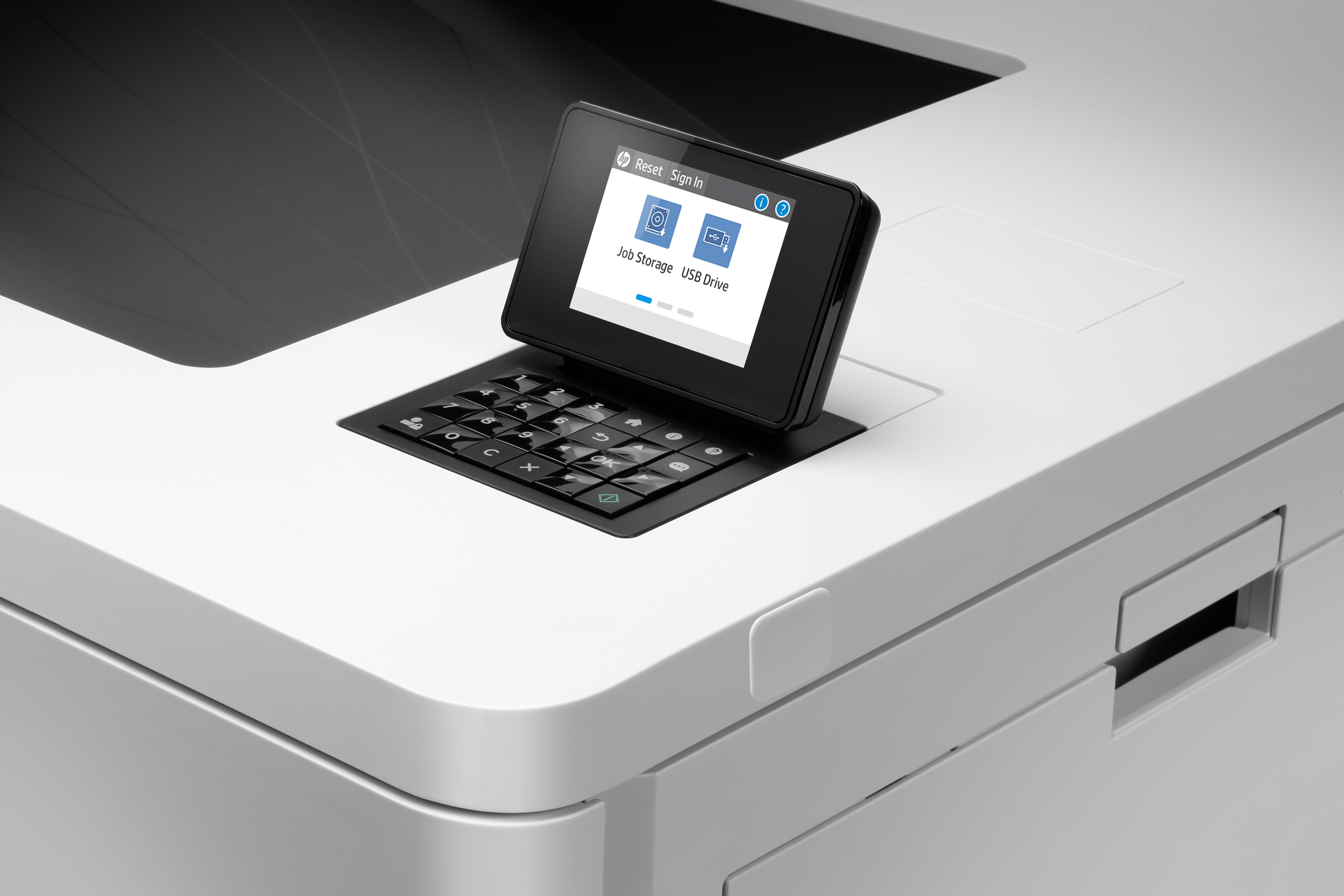 Nahaufnahme des Bedienfelds eines Druckers. Der Bildschirm zeigt Optionen an. Schwarze Tastatur darunter.